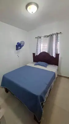 a bedroom with a large bed with a blue blanket at Apartamento acogedor J-A in Los Paredones