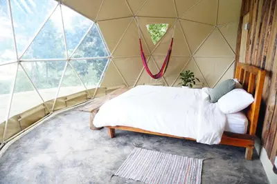 a bedroom in a geodesic dome with a bed at NOMAD Domes at Salto Jimenoa, Jarabacoa in Jarabacoa