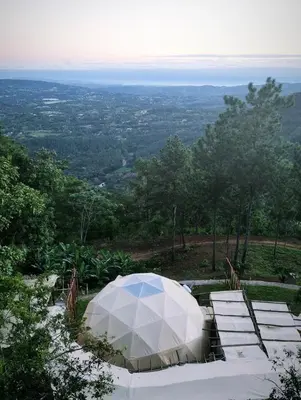 a white tent sitting on top of a hill at NOMAD Domes at Salto Jimenoa, Jarabacoa in Jarabacoa