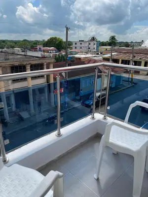 a balcony with two chairs and a view of a street at Plataview Apartahotel apt 3C in Monte Plata