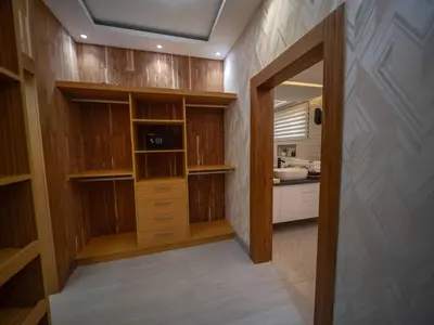 a walk in closet with wooden cabinets and a kitchen at Luxurious Listed New Villa With 5 Br- 6 Bt In Sosua in Sosúa