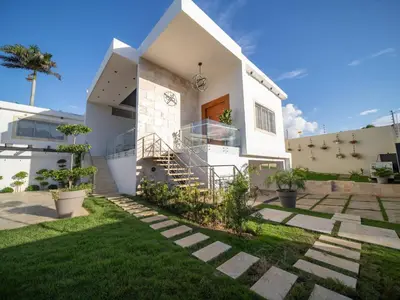 a white house with a green yard at Luxurious Listed New Villa With 5 Br- 6 Bt In Sosua in Sosúa