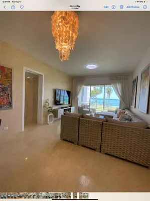 a living room with a couch and a chandelier at SEAWINDS CABARETE Front beach Condo in Cabarete