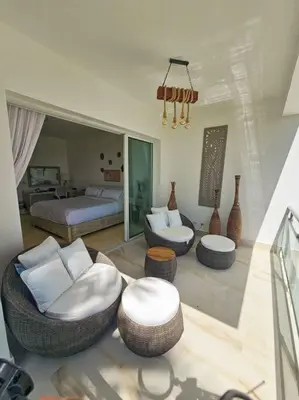 a living room with a bed and chairs and a room with a bed at SEAWINDS CABARETE Front beach Condo in Cabarete
