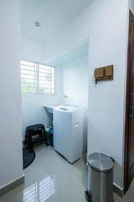 a white room with a refrigerator and a trash can at Breezes by TECASA in Santiago de los Caballeros