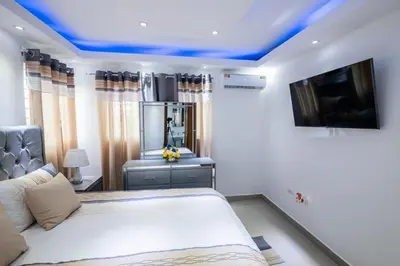 a bedroom with a bed with a blue ceiling at Breezes by TECASA in Santiago de los Caballeros