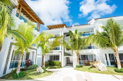 an exterior view of a white building with palm trees at Estrella Dominicus Ekskluzywny Apartament ,,Bajeczny Widok,, in La Laguna