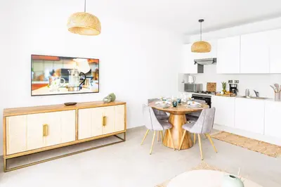 a kitchen with a wooden table and chairs at Estrella Dominicus Ekskluzywny Apartament ,,Bajeczny Widok,, in La Laguna