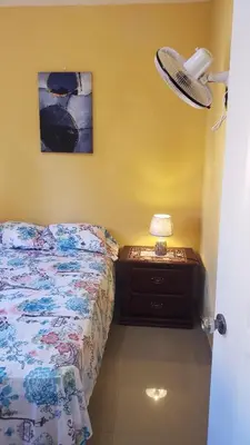 a bedroom with a bed and a lamp on a night stand at Petite Lounge in Los Paredones