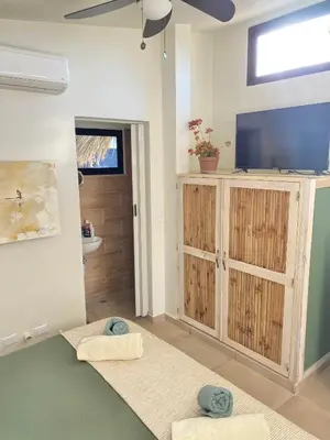 a living room with a television and a bathroom at Sfeervolle studio in Encuentro Cabarete in Cabarete
