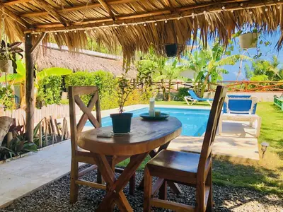 a wooden table and two chairs and a pool at Sfeervolle studio in Encuentro Cabarete in Cabarete