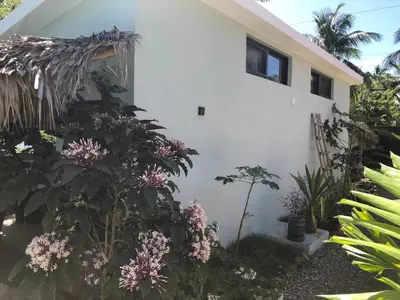 a white house with flowers in front of it at Sfeervolle studio in Encuentro Cabarete in Cabarete