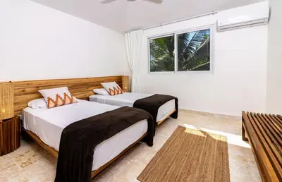 two beds in a room with a window at Surf and Yoga Retreat for Groups Near Cab! in Gaspar Hernández