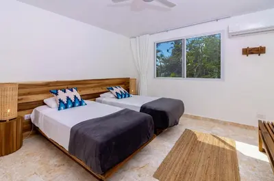 two beds in a room with a window at Surf and Yoga Retreat for Groups Near Cab! in Gaspar Hernández
