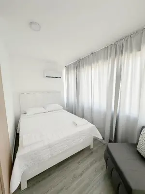 a bedroom with a white bed and white curtains at La Yarolina in Punta Cana