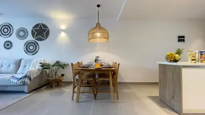 a kitchen and living room with a table and chairs at Tropical Relaxing 2 Bedroom Unit with picuzzi in Punta Cana
