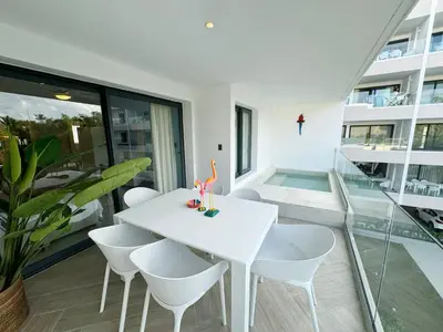 a white dining room with a white table and chairs at Tropical Relaxing 2 Bedroom Unit with picuzzi in Punta Cana