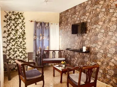 a living room with chairs and a stone wall at Agradable Apartamento in Paraíso