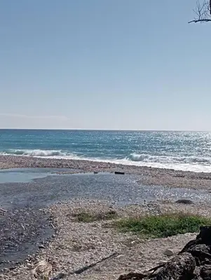 a rocky beach with the ocean in the background at Agradable Apartamento in Paraíso