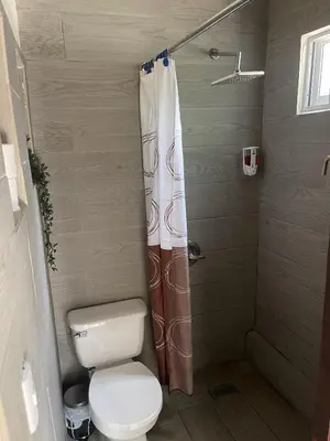 a bathroom with a toilet and a shower curtain at Island Life Hostel in Santo Domingo