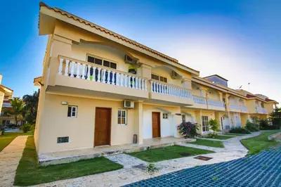 a large yellow building with a balcony at Las Palmeras by Graziano in Boca Chica