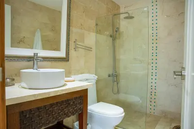 a bathroom with a shower and a sink and a toilet at Riviera Azul -2 Hab con vista a la Piscina - cash only or paypal in San Felipe de Puerto Plata