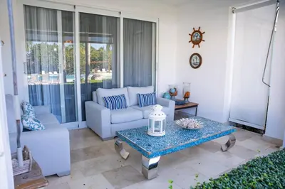 a living room with a couch and a table at Riviera Azul -2 Hab con vista a la Piscina - cash only or paypal in San Felipe de Puerto Plata
