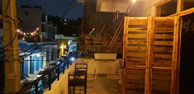 a balcony with chairs and a window at night at Tus Recuerdos in Santo Domingo