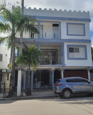 a car parked in front of a blue house at Marmota House in Santa Bárbara de Samaná