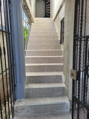 a staircase leading up to a building with wrought iron gates at Marmota House in Santa Bárbara de Samaná