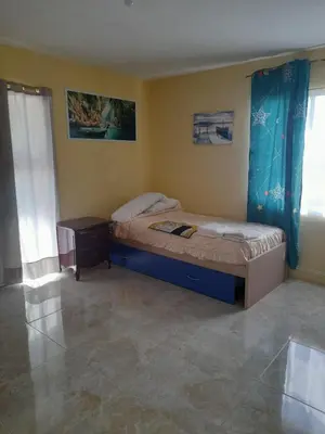 a small bedroom with a bed and a night stand at Marmota House in Santa Bárbara de Samaná