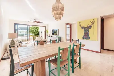 a dining room with a large wooden table and chairs at Comfortable and charming apartment at Portillo WF in Las Terrenas