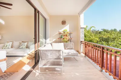 a balcony with a couch and a chair at Comfortable and charming apartment at Portillo WF in Las Terrenas