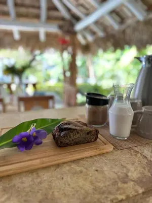 a piece of bread on a cutting board with a purple flower at Villa Clarissa No. 8 in Las Terrenas