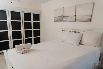 a bedroom with a white bed with a hat on it at Oceanfront 3 Bedroom With Jacuzzi and Pool in Santo Domingo