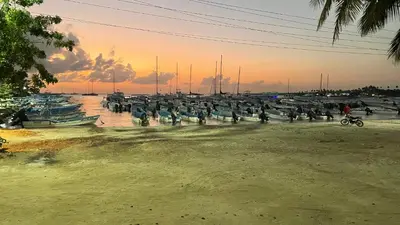 a group of people standing in the water near boats at Dominicus Castillo Paradise in La Laguna