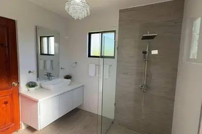 a bathroom with a glass shower and a sink at Private Getaway - Sosua in Sosúa