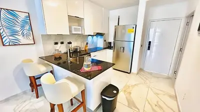 a kitchen with a table and a refrigerator at Cana Rock Star-Two apartments very close-Ground floor direct access to the pool in Punta Cana
