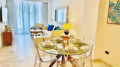 a living room with a table and chairs and a couch at Cana Rock Star-Two apartments very close-Ground floor direct access to the pool in Punta Cana