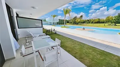 a living room with a view of a swimming pool at Cana Rock Star-Two apartments very close-Ground floor direct access to the pool in Punta Cana