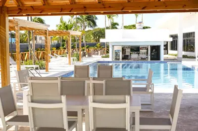 a table and chairs next to a swimming pool at Habana Hotel Y Restaurante in Higuey
