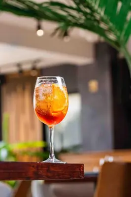 a glass with an orange in it sitting on a table at Habana Hotel Y Restaurante in Higuey