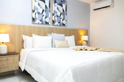 a bedroom with a large white bed and two lamps at Habana Hotel Y Restaurante in Higuey