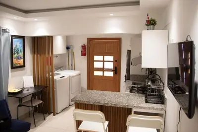 a small kitchen with a counter and a table at Casa de Nini in Santo Domingo