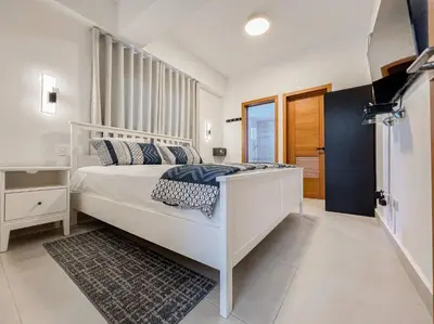 a bedroom with a white bed and a window at Goistay Elegant Refugio Caribeo 1br Gym Pool Naco in Santo Domingo