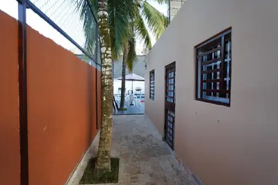 a palm tree next to a building with a hallway at Villa Sol Taino, Hotel en Boca chica, 5 minutos del Aeropuerto Internacional las Américas in La Golondrina