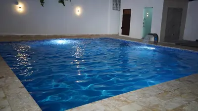 a large pool with blue water in a room at Villa Sol Taino, Hotel en Boca chica, 5 minutos del Aeropuerto Internacional las Américas in La Golondrina
