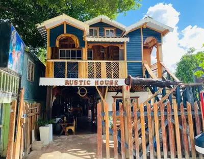 a large wooden house with a wooden fence in front of it at Rustic House 2 in Punta Rucia