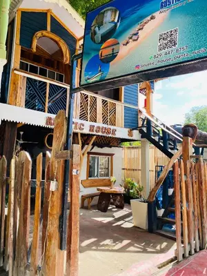a house with a surfboard on the side of it at Rustic House 2 in Punta Rucia