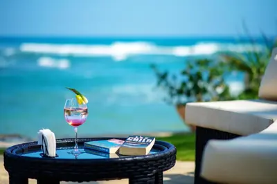 a glass of wine on a table next to a pool at Velero Beach Resort in Cabarete